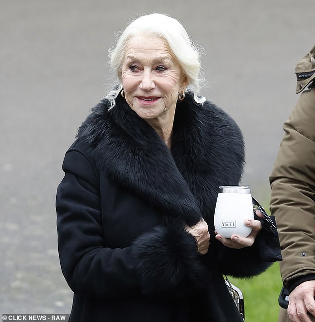 Dame Helen Mirren is pictured in character as Maeve, dressed in sombre black lace under a fur-trimmed black coat