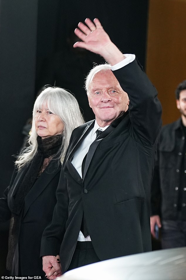 Dressed in a sharp black suit and a classic white button-up shirt, he posed for photos alongside his wife Stella on the red carpet