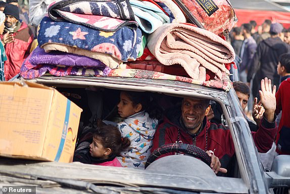 A displaced Palestinian man waves from a car loaded with belongings following a delay in the ceasefire set for Sunday morning over the hostage list, in Khan Younis in the southern Gaza Strip, January 19, 2025. REUTERS/Mohammed Salem     TPX IMAGES OF THE DAY