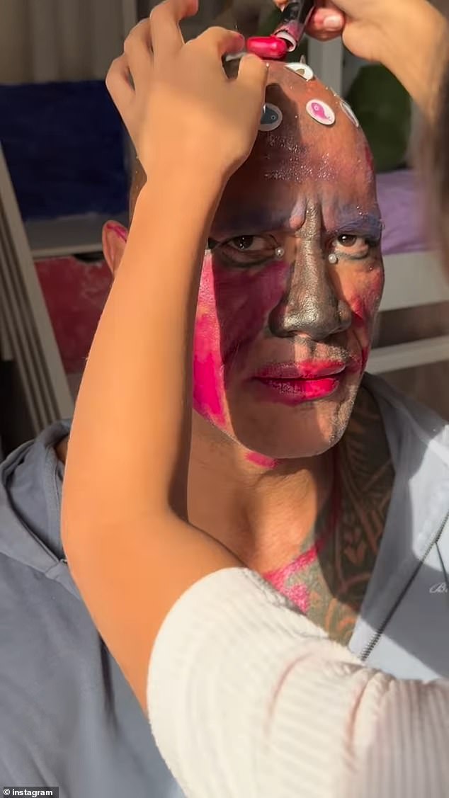 In the hilarious clip, Johnson put on a brave face as he allowed the youngsters to apply glitter to his bald head and vibrant face paint to his visage