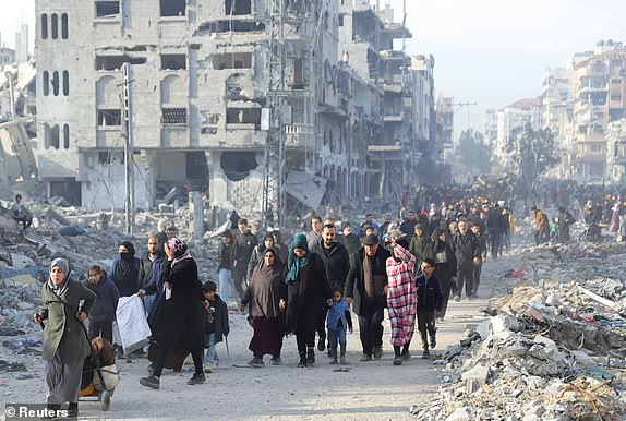 Displaced Palestinians make their way past rubble, as they attempt to return to their homes, following a delay in the ceasefire between Israel and Hamas over the hostage list, in the northern Gaza Strip, January 19, 2025. REUTERS/Khalil Ramzi