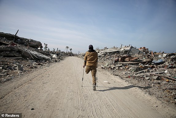 A displaced Palestinian makes his way past rubble, as Palestinians attempt to return to their homes, following a delay in the ceasefire between Israel and Hamas over the hostage list, in Rafah, in the southern Gaza Strip January 19, 2025. REUTERS/Hatem Khaled     TPX IMAGES OF THE DAY