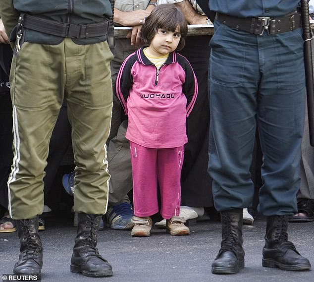 A young girl attends the hanging of Majid Kavousifar and Hossein Kavousifar in Tehran