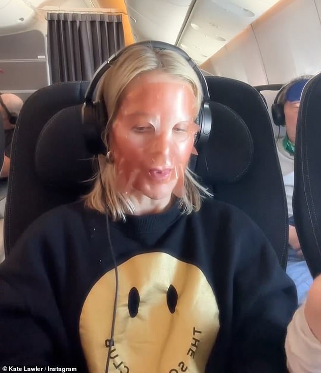 She dressed casually for the flight with a black jumper on and was listening to music with her headphones on