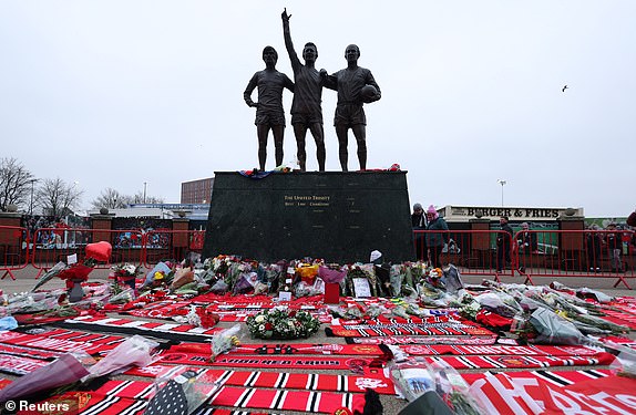 Soccer Football - Premier League - Manchester United v Brighton & Hove Albion - Old Trafford, Manchester, Britain - January 19, 2025 Flowers are laid in front of the Trinity statue in memory of former Manchester United player Denis Law outside the stadium before the match REUTERS/Phil Noble EDITORIAL USE ONLY. NO USE WITH UNAUTHORIZED AUDIO, VIDEO, DATA, FIXTURE LISTS, CLUB/LEAGUE LOGOS OR 'LIVE' SERVICES. ONLINE IN-MATCH USE LIMITED TO 120 IMAGES, NO VIDEO EMULATION. NO USE IN BETTING, GAMES OR SINGLE CLUB/LEAGUE/PLAYER PUBLICATIONS. PLEASE CONTACT YOUR ACCOUNT REPRESENTATIVE FOR FURTHER DETAILS..