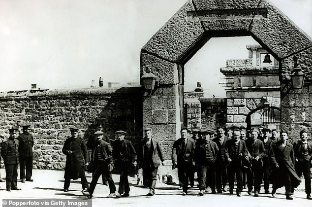 Pictured: British conscientious objectors leaving Dartmoor Prison under a gateway with the words "Parcere subjectis" (Spare the conquered)