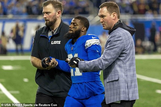 Detroit Lions corner back Amik Robertson (21) walks off the field assisted by trainers during the first quarter against the Washington Commanders at Ford Field