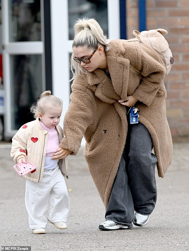 She shielded her eyes behind chic shades and tied back her long blonde locks into a ponytail