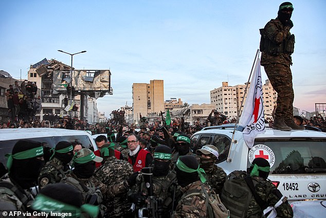 Members of the International Committee of the Red Cross (ICRC) speak with fighters of the Ezzedine al-Qassam Brigades, Hamas's armed wing, in Saraya Square in western Gaza City on January 19, 2025