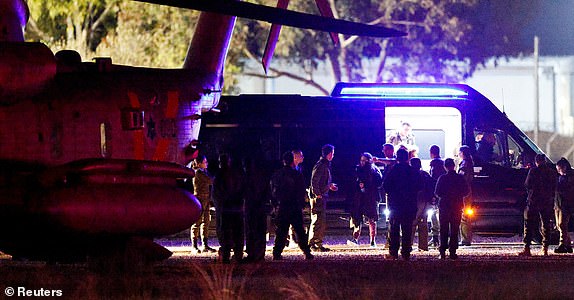 People walk towards Israeli military helicopters as Romi Gonen, Doron Steinbrecher and Emily Damari, three female hostages who have been held in Gaza since the deadly October 7 2023 attack, return to Israel as part of a ceasefire deal in Gaza between Hamas and Israel, by Israel's border with Gaza in southern Israel, January 19, 2025. REUTERS/Amir Cohen     TPX IMAGES OF THE DAY