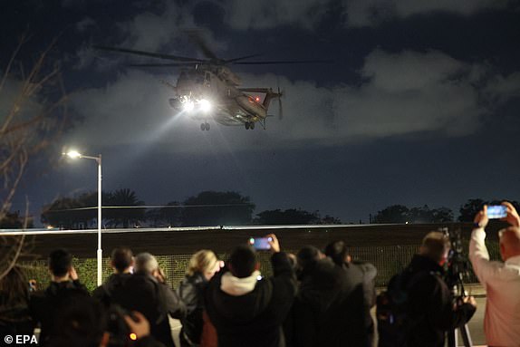 epa11837259 People gather to watch the military helicopter carrying three Israeli female hostages, Romi Gonen, Emily Damari and Doron Steinbrecher land at Sheba Medical Center in Ramat Gan, Israel, 19 January 2025. The three Israeli female hostages, Romi Gonen, Emily Damari and Doron Steinbrecher received medical treatment after crossing into Israeli territory and met with their families at Sheba Medical Center where they will continue their medical rehabilitation. Israel and Hamas agreed on a hostage release deal and a Gaza ceasefire to be implemented on 19 January 2025.  EPA/ABIR SULTAN