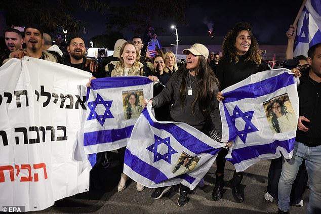 People gather to watch the military helicopter carrying the three Israeli female hostages