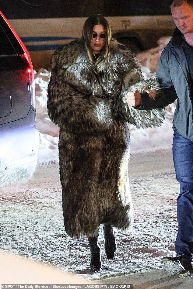 The 28-year-old IMG Model wore sunglasses at night and covered up in a massive faux-fur grey coat and glossy black high-heeled boots