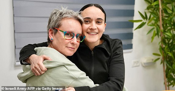 This handout picture released by the Israeli army shows former Israeli hostage Emily Damari with her mother Amanda at an undisclosed location in Israel on January 19, 2025 after a ceasefire and hostage-prisoner exchange deal in the war between Israel and Hamas was implemented. The first three Israeli hostages were released on January 19 under a long-awaited Gaza truce aimed at ending more than 15 months of war that has ravaged the Palestinian territory. The Hostage and Missing Families Forum campaign group had identified the three women set to be released as Emily Damari, Romi Gonen and Doron Steinbrecher. (Photo by Israeli Army / AFP) / === RESTRICTED TO EDITORIAL USE - MANDATORY CREDIT "AFP PHOTO / Handout / Israeli Army' - NO MARKETING NO ADVERTISING CAMPAIGNS - DISTRIBUTED AS A SERVICE TO CLIENTS == (Photo by -/Israeli Army/AFP via Getty Images)