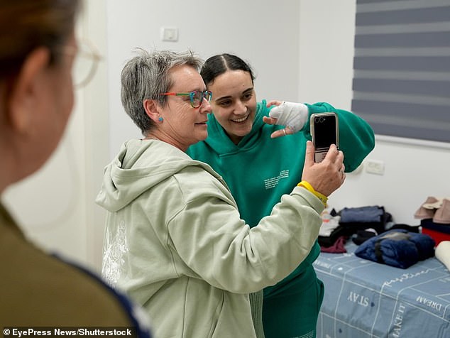 Emily cheerfully waves her bandaged hand as she video-called relatives with her mother