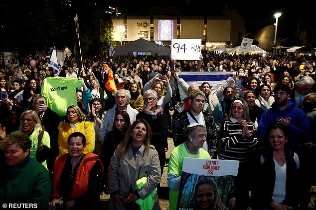 People react as they watch news coverage of the release of Romi Gonen, Doron Steinbrecher and Emily Damar