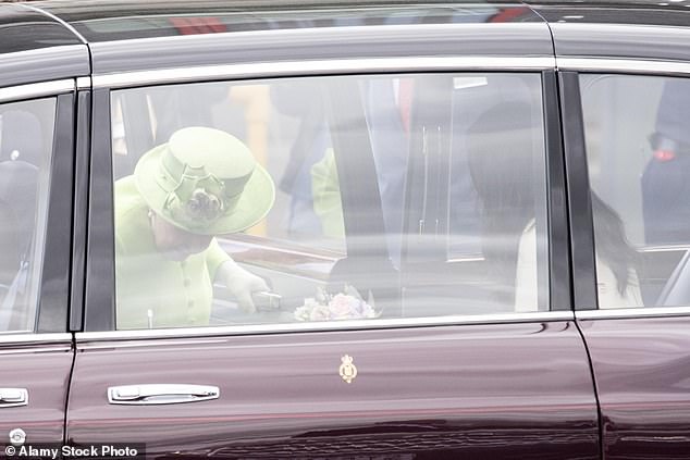 The Queen is then pictured following behind Meghan to sit behind the driver