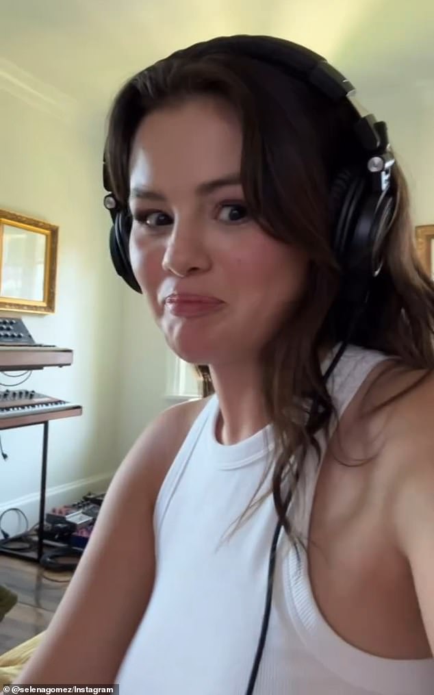 The 32-year-old multihyphenate wore a white tank top and had black headphones over her ears while playing a snippet of music at a low, muffled volume