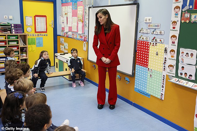 Queen Letizia looks in high spirits as she stands in front of the class during her trip to a school