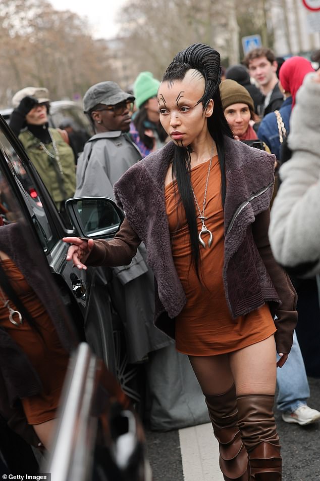 She also sported a long silver pendant necklace which went down to her midriff as fans gathered at the Rick Owens store in the Jardin du Palais Royal to get a glimpse of the star