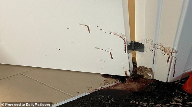 Splattered blood extended up the door and the doorframe about 18 inches, dripping down to the floor, and a splash extended just past the threshold on the bathroom tiles