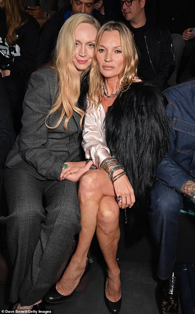 Kate Moss put on a cosy display with her actress pal Gwendoline Christie as they sat in the front row at the Dior Homme show during Paris Fashion Week on Friday