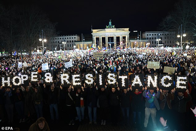 Participants stand with placards during a rally against the far right at the Brandenburg Gate in Berlin, Germany, 25 January 2025