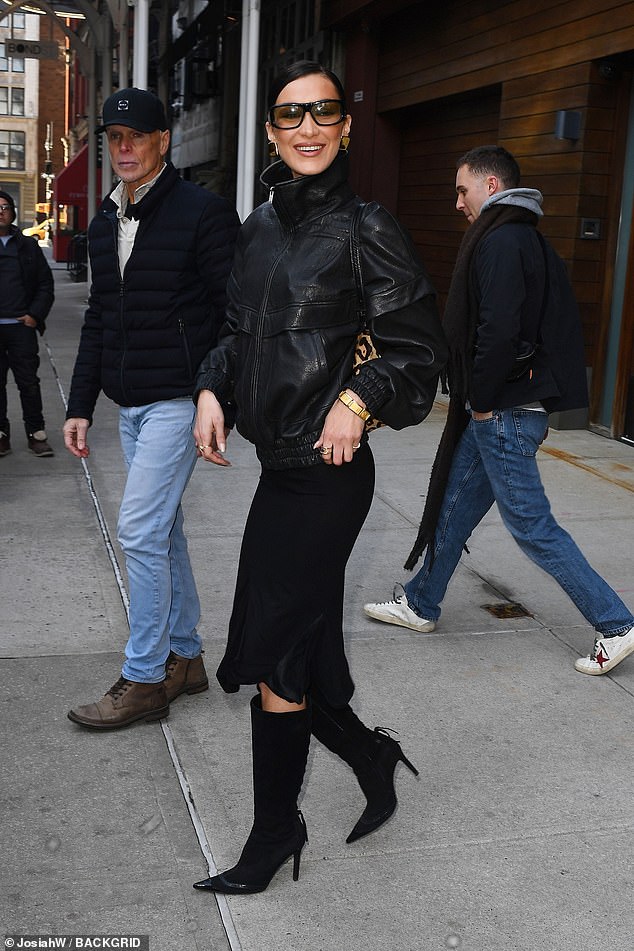 The model, 28, commanded attention in an edgy black leather jacket paired with silky skirt and knee-high suede boots