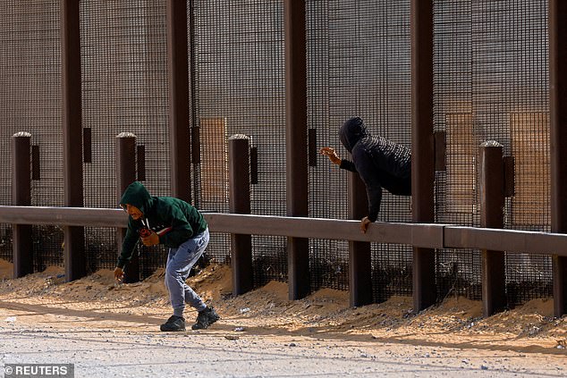 Migrants try to enter the United States undetected, through a hole in a section of the US-Mexico border wall, in Sunland Park, New Mexico on January 28, 2025