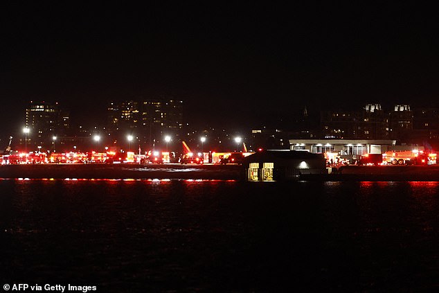 Lights from emergency vehicles are seen at Reagan National Airport in Washington, DC, after an air crash near the Potomac Rive