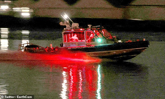 A search and rescue boat operates along the Potomac River near the site of the crash after American Eagle flight 5342 collided with a helicopter