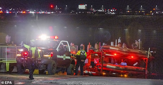 epaselect epa11862689 Rescue teams stage to help search the Potomac River after a commercial airplane reportedly collided with a military helicopter on approach to Ronald Reagan National Airport in Washington, DC, USA, 29 January 2025. According to a preliminary statement from the United States Federal Aviation Administration (FAA), a PSA Airlines Bombardier CRJ700 regional jet that departed earlier today from Wichita, Kansas collided in midair with a Sikorsky H-60 helicopter while on approach to Reagan Washington National Airport.  EPA/SHAWN THEW