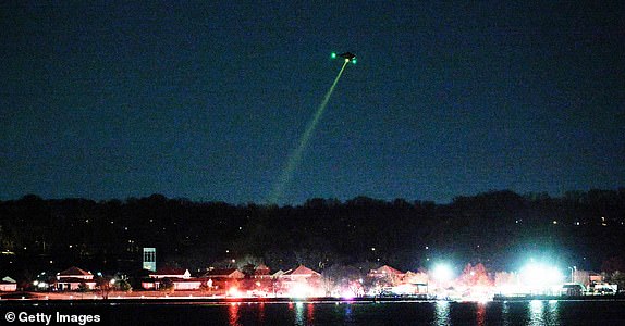 ARLINGTON, VIRGINIA - JANUARY 30: A helicopter assists with search and rescue operations over the Potomac River near Ronald Reagan Washington Airport on January 30, 2025 in Arlington, Virginia. Early reports indicate a helicopter and airplane collided near Reagan National Airport. (Photo by Chip Somodevilla/Getty Images)