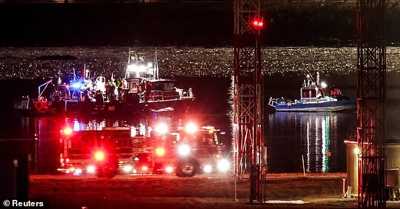 Emergency personnel and divers work at the site of the crash after American Eagle flight 5342 collided with a Black Hawk helicopter while approaching Reagan Washington National Airport and crashed into the Potomac River, outside Washington, U.S., January 30, 2025. REUTERS/Carlos Barria