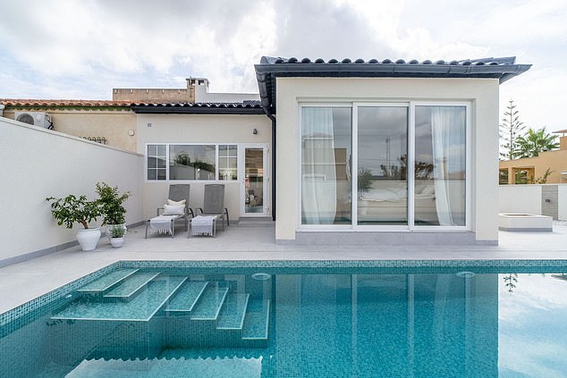 This swish, fully renovated, single-storey villa in the coastal city of Torrevieja, south-east Spain, features large windows allowing for an abundance of natural light and an enticing terrace to its pool