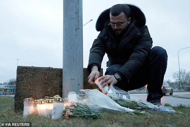 A man lights a candle near the Campus Risbergska school, following a deadly shooting attack at the adult education center in Orebro, Sweden, February 5, 2025