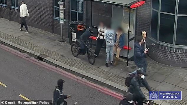 A masked gang riding e-bikes snatched a phone from a woman at a bus stop