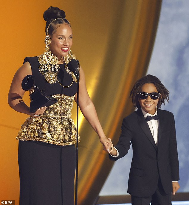 Alicia pictured with Genesis as she accepts the Grammy for the Dr. Dre Global Impact Award