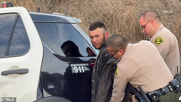 He was then handcuffed and led into the back of a police vehicle