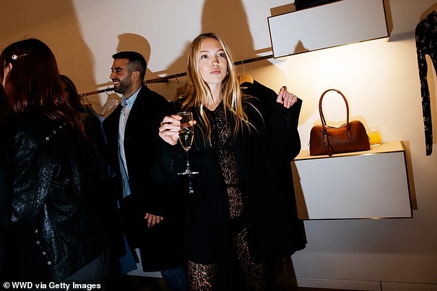 Lila sported the same revealing black lace dress as she enjoyed a drink at the party