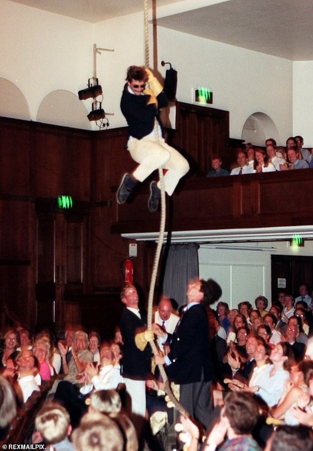 Photographs obtained by the Mail show the star aged 24 making a dramatic entrance into the packed hall of The Royal Geographical Society from a skylight above - dangling from a rope