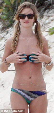 Neck wear: Rosie Huntington-Whiteley donned an unusual chain around her body as she took to the beach with boyfriend Jason Statham yesterday