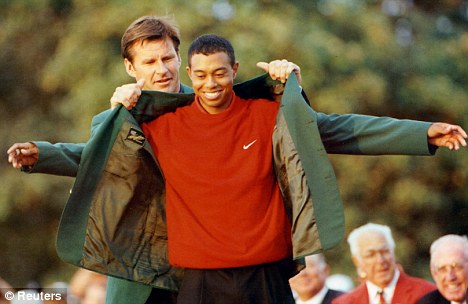 Rising star: Nick Faldo helps Tiger Woods into the famous green jacket after 1997 Masters victory with a record-breaking 18 under par at Augusta. The new PGA Tour game is based on the Masters