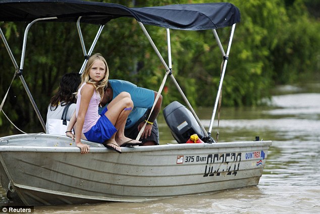 Boats only: A girl prepares to jump out of her family's craft as they only way to access parts of Rockhampton