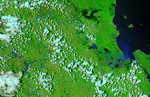 'Biblical': A satellite image from NASA shows the Fitzroy River before the flooding and, below, the scale of the devastation is apparent