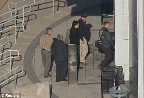 Treading carefully: Law enforcement officials are pictured entering the Maryland Department of Transport headquarters in Hanover, Maryland, after the alert today