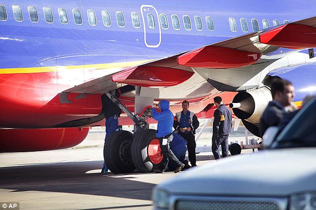 Investigation: A Crew inspects Southwest Airlines Flight 4013  at tiny M. Graham Clark Airport in Hollister, Missouri on Monday, where pilots accidentally landed while en route to Branson Sunday evening