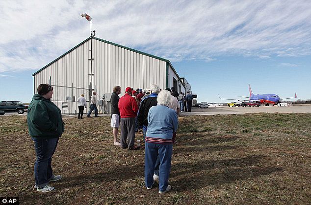 Uncommon around these parts: A small crowd gathers at the M. Graham Clark Airport in Hollister, Missouri Monday to see Southwest Airlines jet that landed there by mistake. The pilots who mistakenly landed the jet there Sunday were grounded Monday pending an investigation