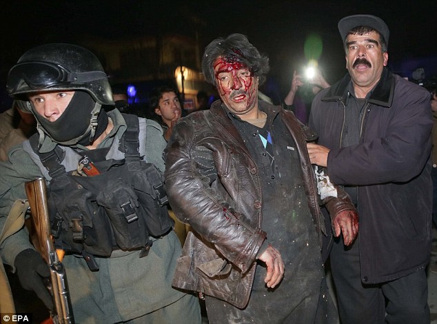 Wounded: Police carry an injured victim from the scene of a suicide bombing in a restaurant in Kabul, Afghanistan