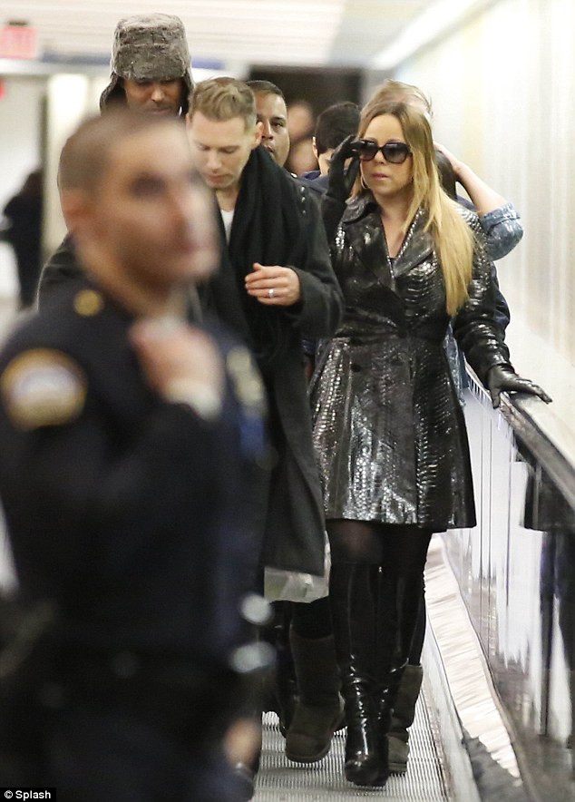 Back in black: The 43-year-old diva wore a shiny black alligator coat that gleamed under the glare of the airport lights